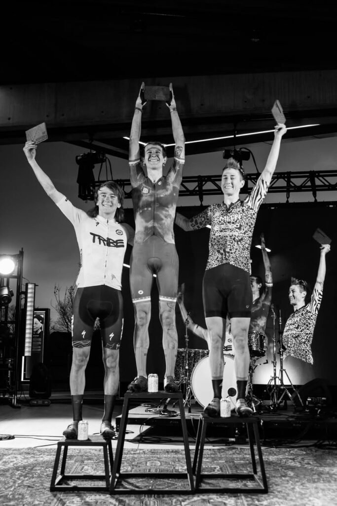 The winners of the 2026 MidSouth Pro Non-binary field stand on the podium, arms held high.