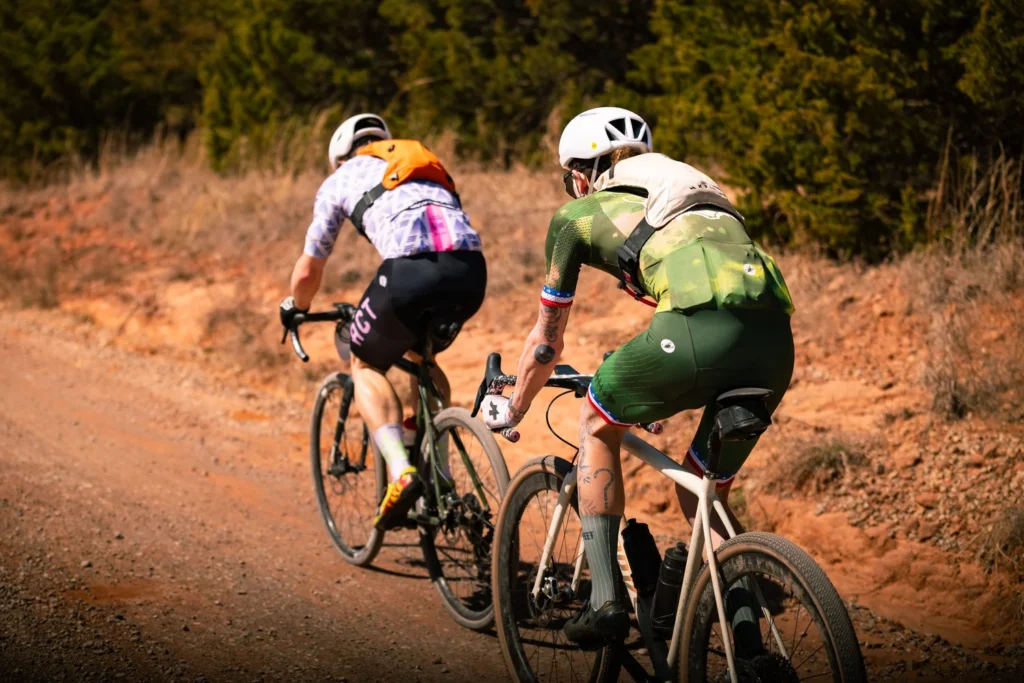 Robin Cummings and Quin Kennedy race gravel bikes on the dirt roads of Stillwater OK off the front of the Pro Non-Binary race.